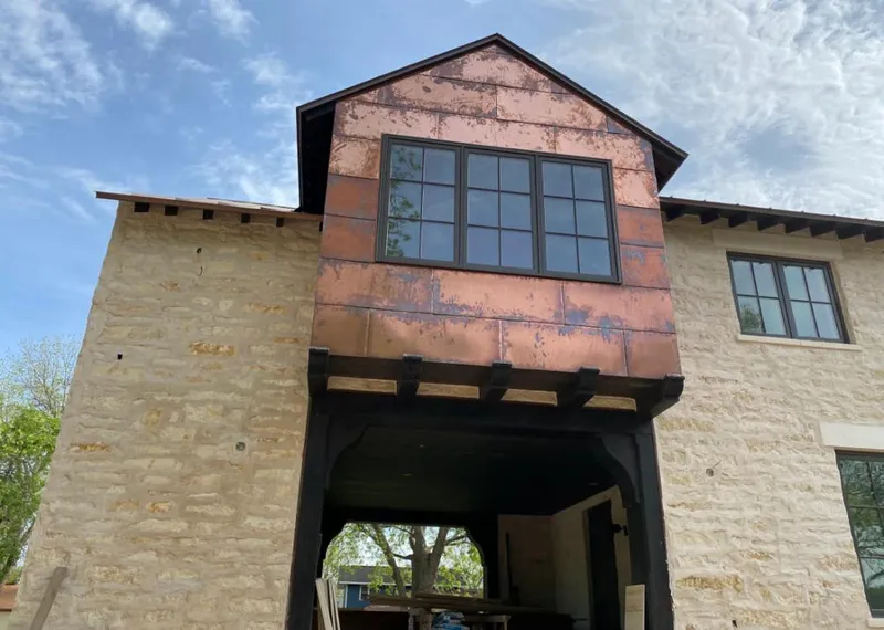 Copper metal panel facade on a stone building for Skylight Installation in Falls